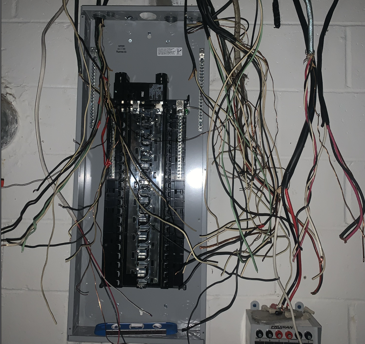 Professional electrician working on open electrical panel with circuit breakers